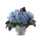 Blue hydrangea and blueberry arrangement in a blue and white ceramic vase