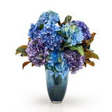 Bouquet of blue and purple hydrangeas in a blue vase on a white background