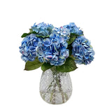 Luxury faux blue hydrangea arrangement in cut glass vase with realistic hydrangea blooms and faux acrylic water