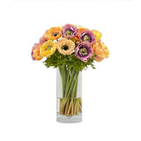 Real Touch anemone mix in yellow lavender coral and cream displayed in a tall clear glass vase.
