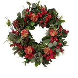 Hand-crafted holiday deluxe wreath with red flowers, berries, and green foliage, displayed against a white background