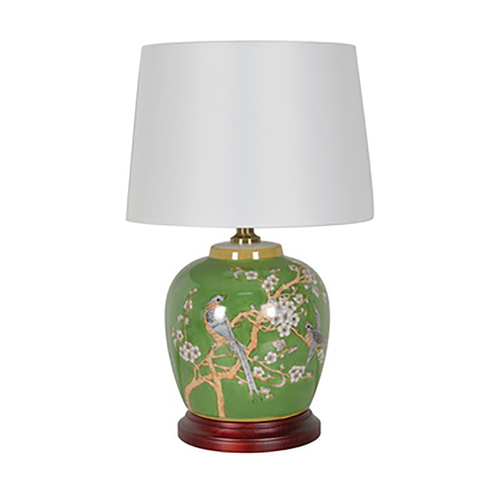 lamp with green bird motif and wooden base and white empire cylinder shade
