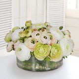 Luxury mixed ranunculus centerpiece in a clear glass vase featuring orange and cream faux blooms