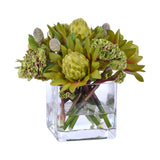 Faux orange and red waratah floral arrangement in a clear square glass vase