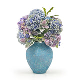 Blue textured vase with hydrangeas on a white background
