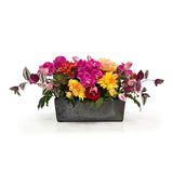 Colorful Dahlia Orchid arrangement in a gray container on a white background