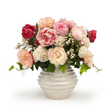 Bouquet of pink, red, and white flowers in a textured white vase on a white background