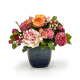 Rose floral arrangement in a blue vase on a white background