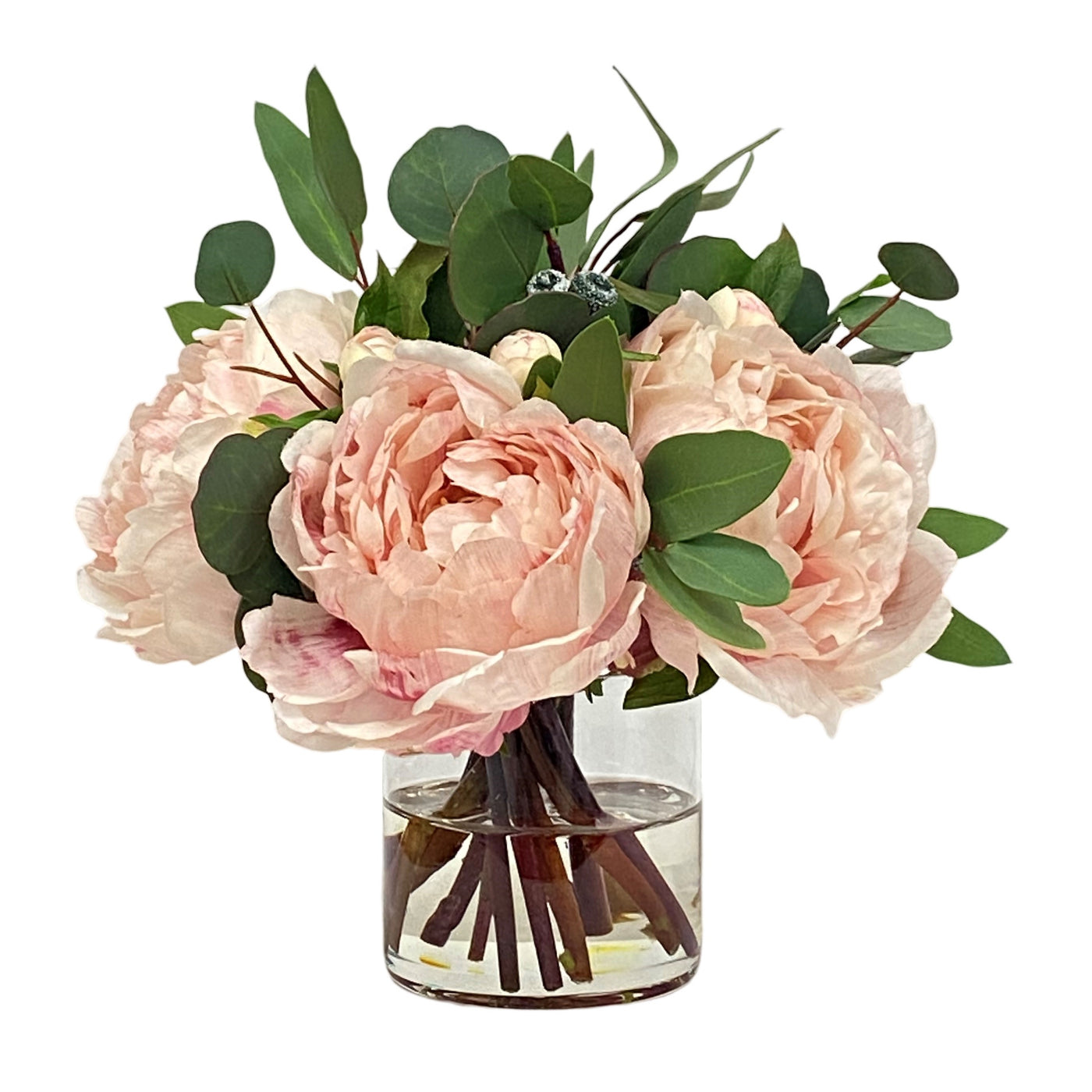Peony Eucalyptus in Cylinder 10.5" sprinkled with Eucalyptus Spray and Stem. soft pink and white hued flowers in clear vase placed against white background.