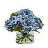Light blue faux hydrangea arrangement in a clear cylinder glass vase