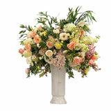 Large faux café au lait floral arrangement with peonies, hydrangeas, and delphiniums in decorative handled vase for luxury interiors