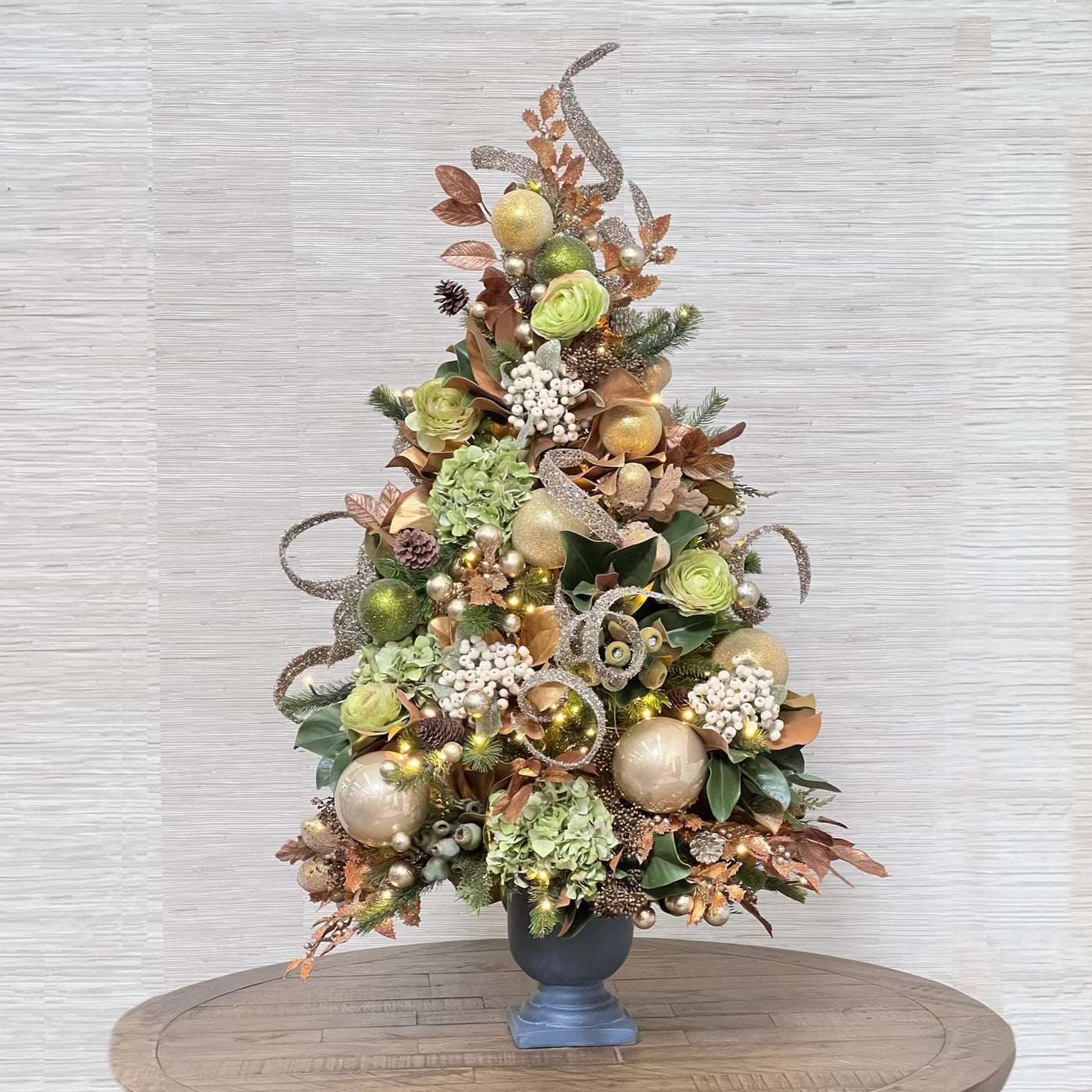 luxury pre-decorated Christmas tree with green and gold ornaments and decor