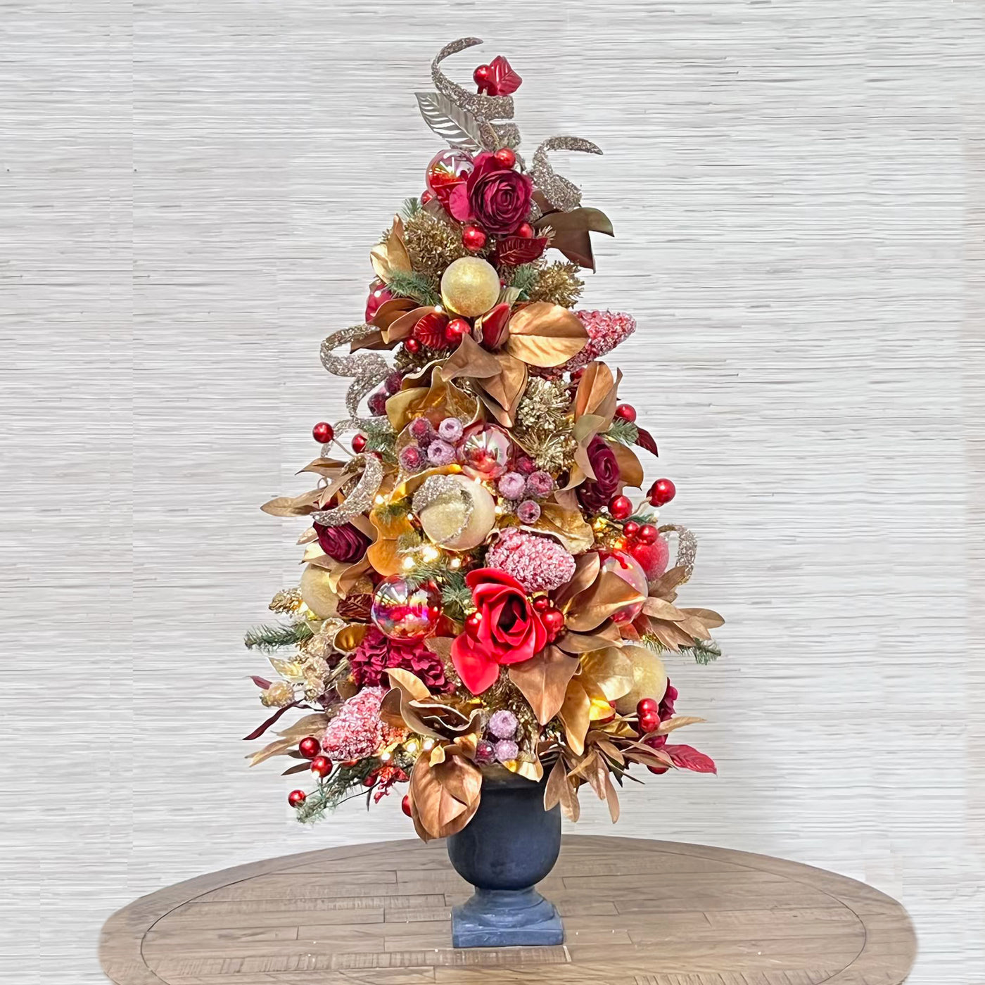 luxury pre-decorated tabletop Christmas tree pre-strung with lights, ornaments, flowers, berries, and more.