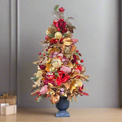 red and gold tabletop Christmas tree pre-decorated with ornaments, flowers, and more