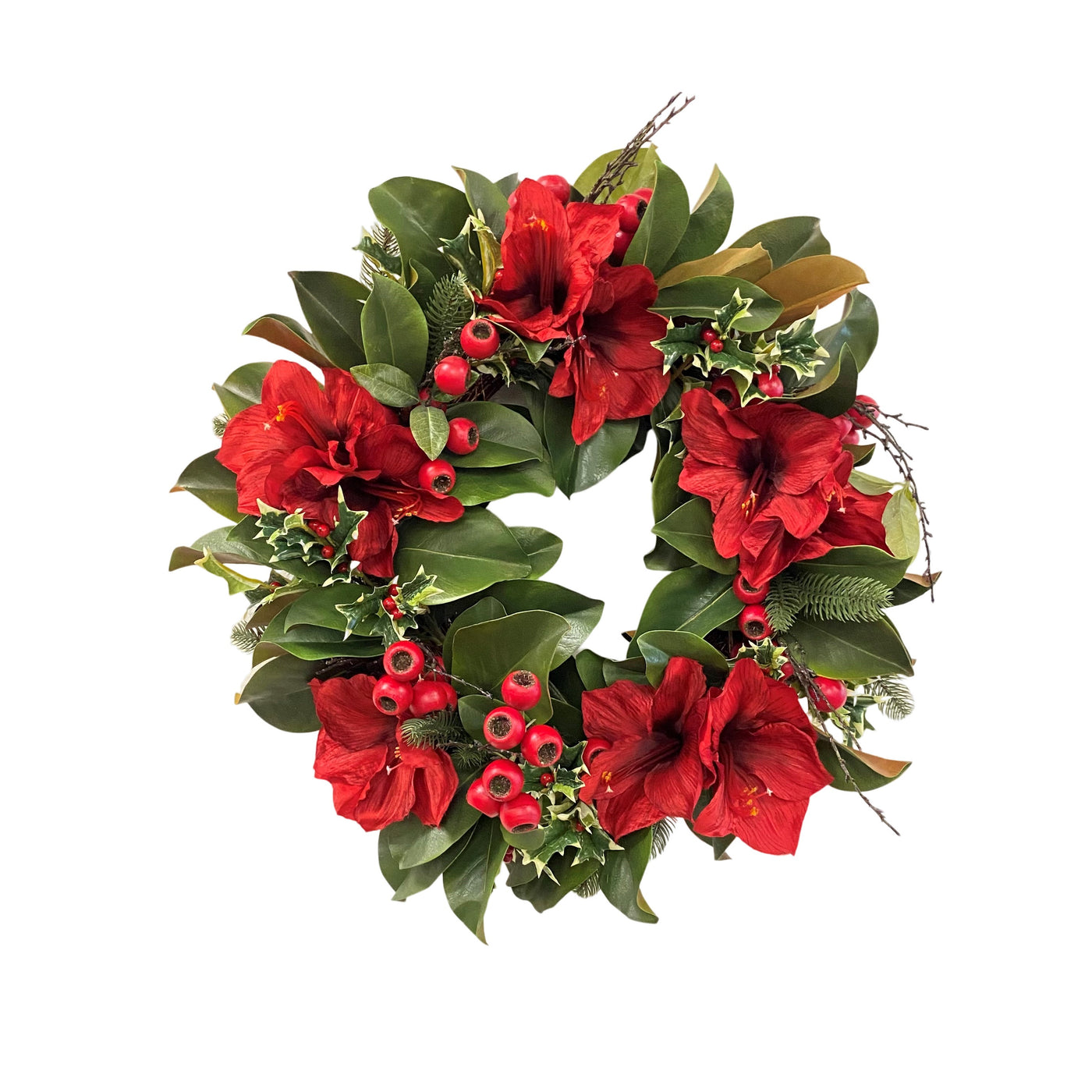 Hand-crafted wreath with red amaryllis blooms and green foliage for festive display against white background