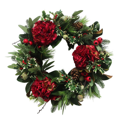Hand-crafted wreath with red hydrangea blooms and green foliage for festive display against white background