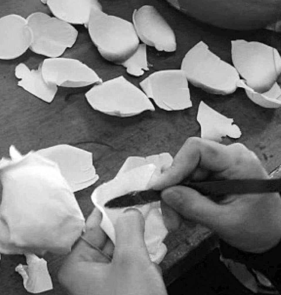 Artisan hand-shaping petals at a workbench