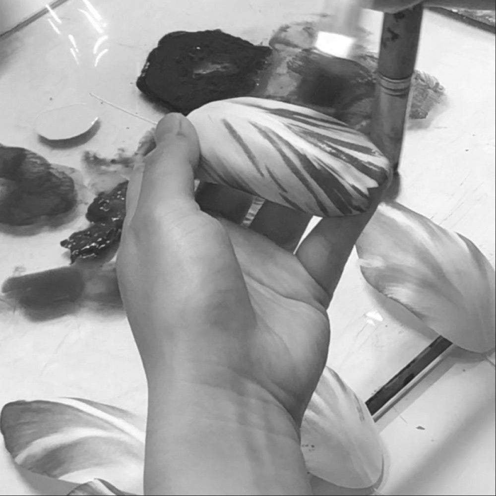 Artisan hand-painting a flower petal