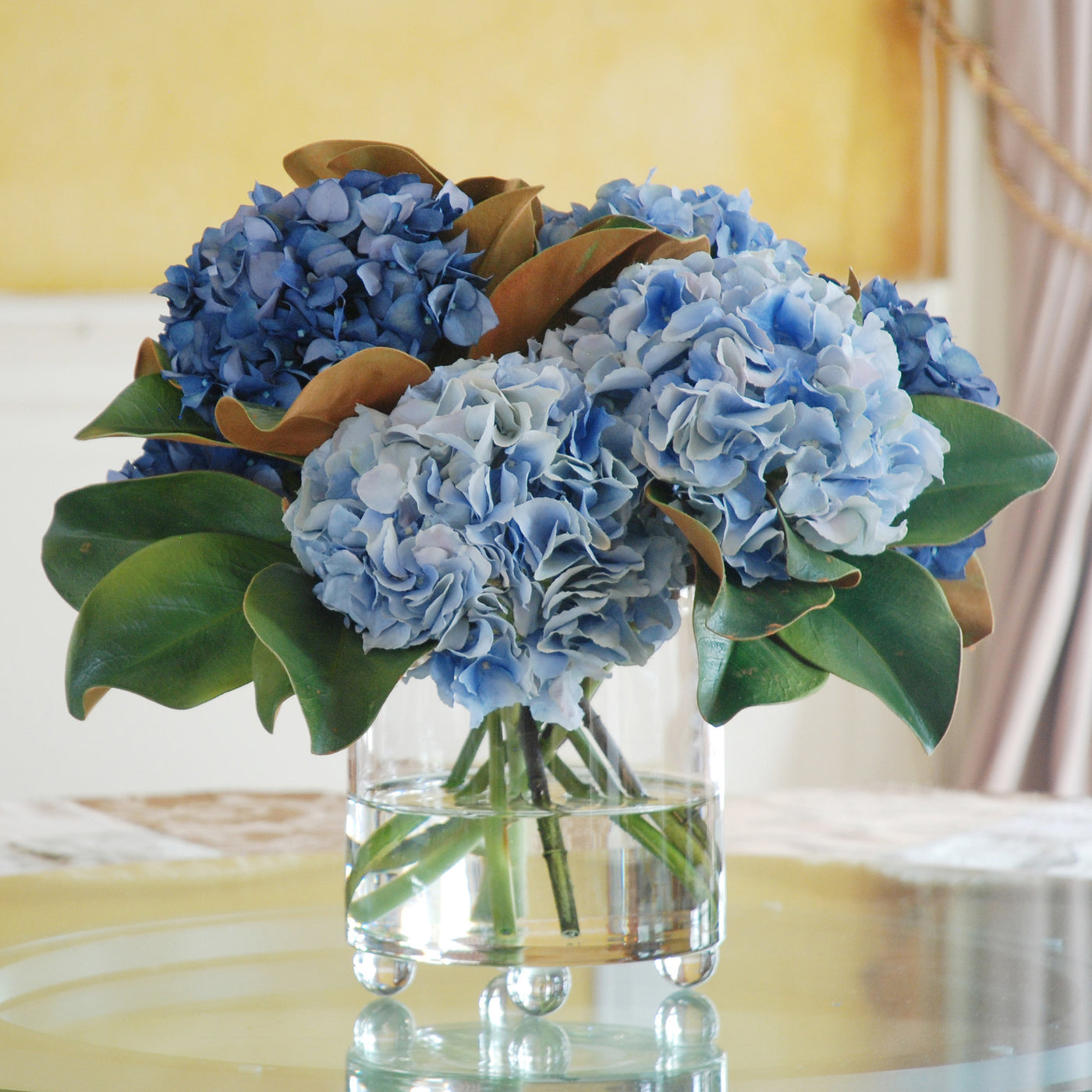 Artificial blue hydrangeas in glass vase