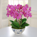 Lavender pink faux orchid arrangement displayed in a blue and white chinoiserie rose trellis bowl