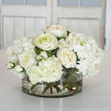 White hydrangea and snowball floral arrangement in clear glass vase with layered blooms for elegant tabletop décor