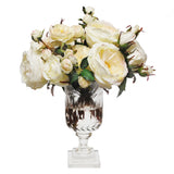 Mixed ivory and cream faux roses arranged in a decorative leaf cut footed glass vase