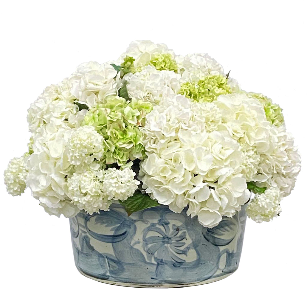 Mixed white and light green hydrangeas in white and light blue ceramic pot