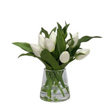 White faux tulips arranged in a clear glass vase