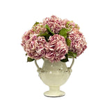 Natural Touch lavender hydrangea arrangement in a taupe Rutherford amphora jar with full rounded blooms and realistic greenery.