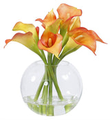 Orange faux calla lily arrangement in a clear glass bubble bowl vase