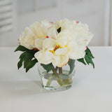 Soft-toned faux peony floral arrangement in a clear glass vase displayed as elegant modern home décor.