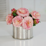 Blush pink faux camellia arrangement displayed in a decorative silver tin container