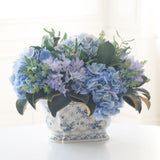 Blue hydrangea and olive leaf faux floral arrangement in a chinoiserie ceramic planter